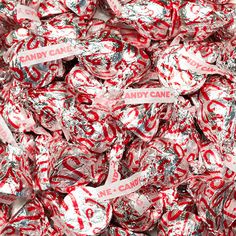 red and white candies with candy canes wrapped in plastic wrapper on top