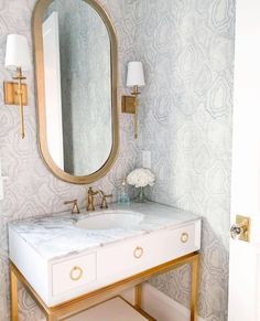 a bathroom vanity with marble top and gold accents