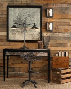 a table with a lamp on it in front of a wooden wall and some crates