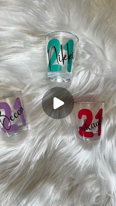 three shot glasses sitting on top of a white fur covered floor next to each other