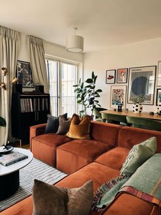 a living room filled with furniture and pictures on the wall next to a coffee table