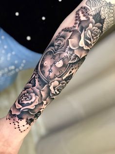 a person with a clock and roses tattoo on their arm