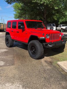 a red jeep parked in a parking lot