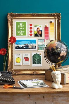 a desk with a globe, keyboard and various stickers on it