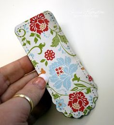 a person is holding a flowered cell phone case in their left hand and the other hand has a ring on it