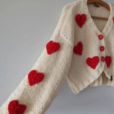 a white sweater with red hearts on it