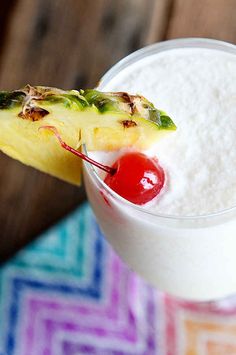 a pineapple drink with a cherry on the rim and garnished in sugar