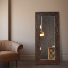 an empty room with a chair, mirror and light fixture on the wall next to it