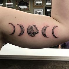 a woman's arm with three phases of the moon tattoo on it