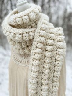 a white knitted scarf hanging from a hook