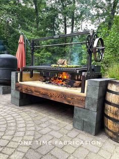 an outdoor fire pit made out of wood and metal with a large wheel on top