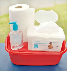 a red tray with two rolls of toilet paper and a soap dispenser