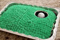 a cake shaped like a hole in the ground with a golf ball on it's side