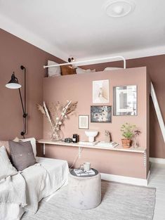 a living room with pink walls and white furniture