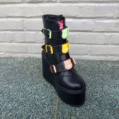 The Yru Dune Lo Care Bear Black Platform Boot Has Different Color Care Bear Heads On Each Adjustable Front Strap, As Well As A 2.75" Platform, 6" Heel, And Back Zipper. #Yru #Yrudunelo #Dunelocarebear #Yrucarebear Black Platform Boots With Ankle Strap, Black Punk Boots With Ankle Strap, Black Edgy Platform Boots With Ankle Strap, Black Punk Ankle Strap Boots, Pink Platform Boots, Yru Shoes, Strappy Platform Heels, Platform Creepers, Platform Heels Boots