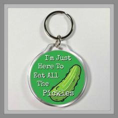 a keychain with a pickle saying i'm just here to eat all the pickles