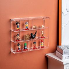 a shelf filled with small figurines on top of a table next to a book