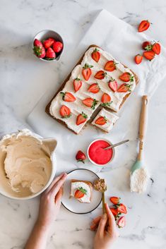 someone is spreading strawberries on top of cake