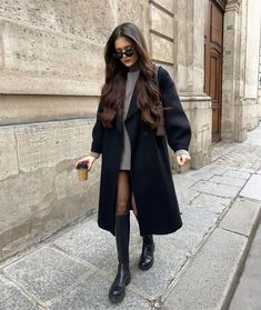 a woman is walking down the street wearing black boots