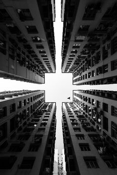 looking up at tall buildings from the ground to the sky in black and white photo