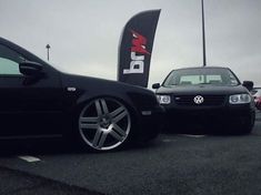 two cars parked next to each other in a parking lot