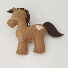 a brown felt horse ornament on a white surface