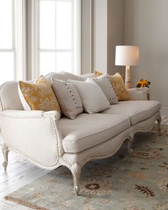 a white couch sitting in front of a window