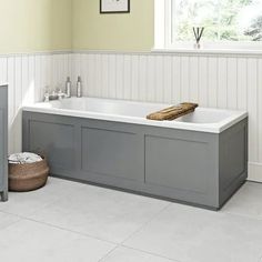 a bath tub sitting next to a window in a room with white walls and flooring