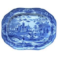 a blue and white platter with an image of a castle in the distance on it