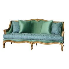 an antique couch with green pillows and gold trimmings on the back, against a white background