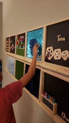 a young boy is placing letters on the wall