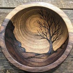 a wooden bowl with a tree painted on it