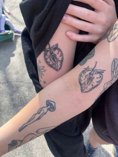 two people with tattoos on their arms holding each other