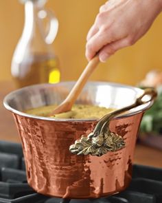 a person stirring something in a pot on the stove