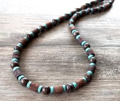 A lightweight beaded mens necklace made with wood, jasper and turquoise blue magnesite beads.  - Length measures 21.5" (more lengths are available) - 8mm beads - Heavy duty beading wire - Stainless steel lobster claw clasp (more types are available)  The length may vary slightly due to the clasp chosen and the nature of the coconut beads. The mannequin's neck size is 14.5".  Our jewelry is not waterproof. We use the highest quality findings to ensure a piece that will last for years to come. DLD jewelry comes with a lifetime guarantee.  Dana LeBlanc Designs- Handmade Jewelry Men’s Beaded Necklace, Mens Beaded Necklaces, 8mm Beads, Mens Necklace, Gemstone Beaded Necklace, Wood Necklace, Bleu Turquoise, Beading Wire, Necklace Gemstone