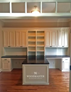 an empty kitchen with white cabinets and wood floors