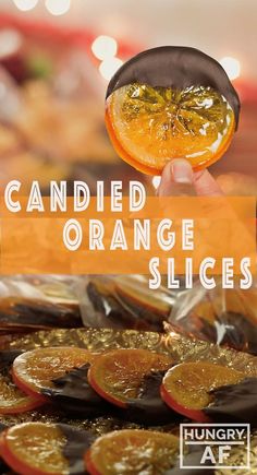 an orange slice is being held up to show it's skin and the words candied orange slices