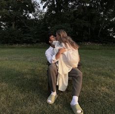 a man and woman are sitting in the grass