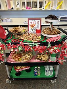 an assortment of food is displayed on a cart in the middle of a room decorated for christmas