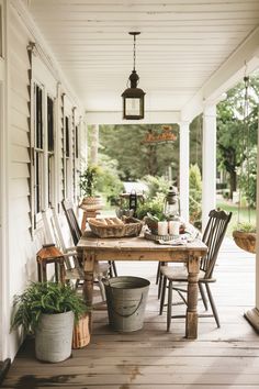 a wooden table sitting on top of a porch next to two buckets filled with food