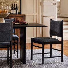 a dining room table with two chairs and a wine rack in the back ground next to it