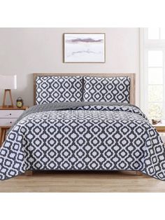 a black and white comforter set with pillows on top of the bedspread