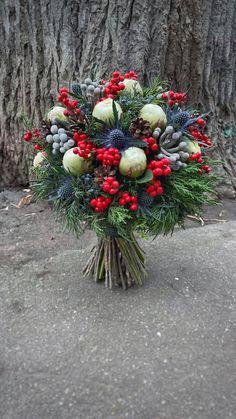 a bouquet of flowers sitting on the ground next to a tree