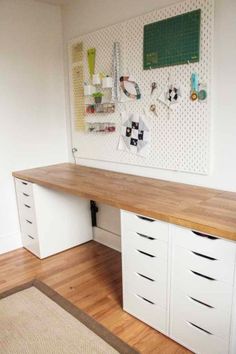 a white desk with lots of drawers and pegboards on the wall above it,