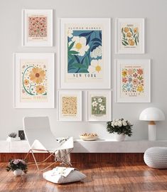 a white room with pictures on the wall and flowers in vases next to it