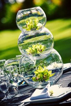 three clear vases filled with flowers on top of a table