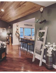 a living room filled with furniture next to a kitchen and dining room table in front of a window