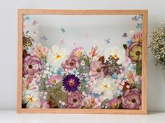 a wooden frame with flowers and butterflies on it