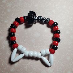 "Sink your teeth into style with our \"I Bite\" Vampire Kandi Single! This eye-catching piece comes complete with a bat charm, capturing the essence of nocturnal allure. Feeling more divine? Opt for crosses - just let us know!  The default colors are as shown, but for a personalized touch, message us to explore the array of customizable color options. Unleash your inner vampire with this uniquely crafted kandi creation!" Kandi Kid, Vampire Fangs, Kandi Patterns, Wilbur Soot, Kandi Bracelets, Scene Kids, Kandy