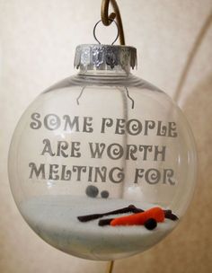 a glass ornament with some writing on it and scissors hanging from the top